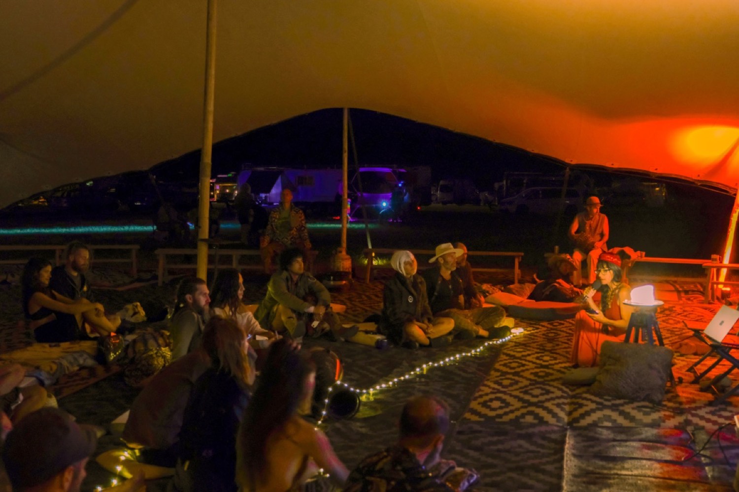 Seekers gathered in a stretch tent at dusk, Burners Without Borders