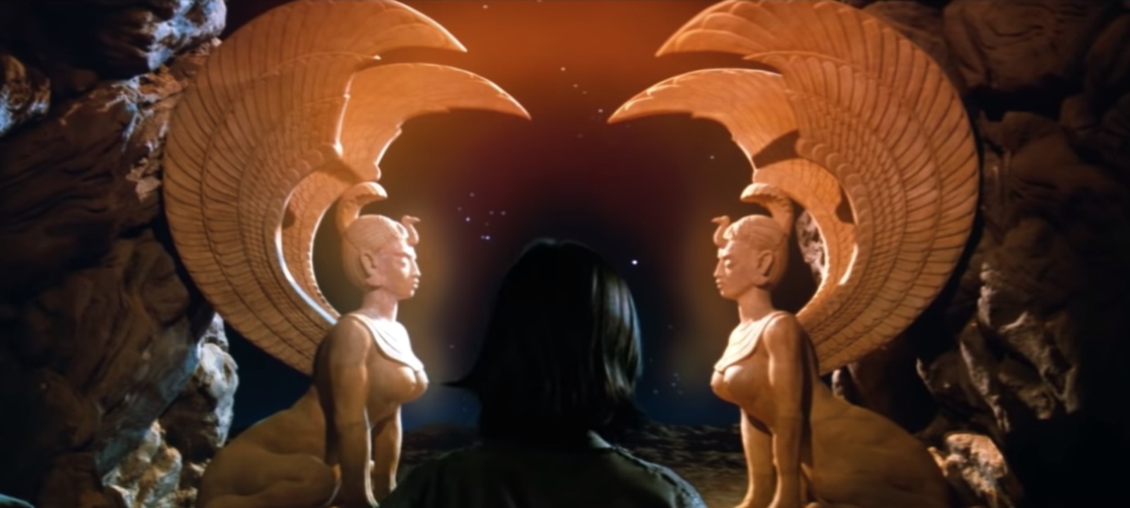 Two winged sphinxes facing across the cosmic threshold