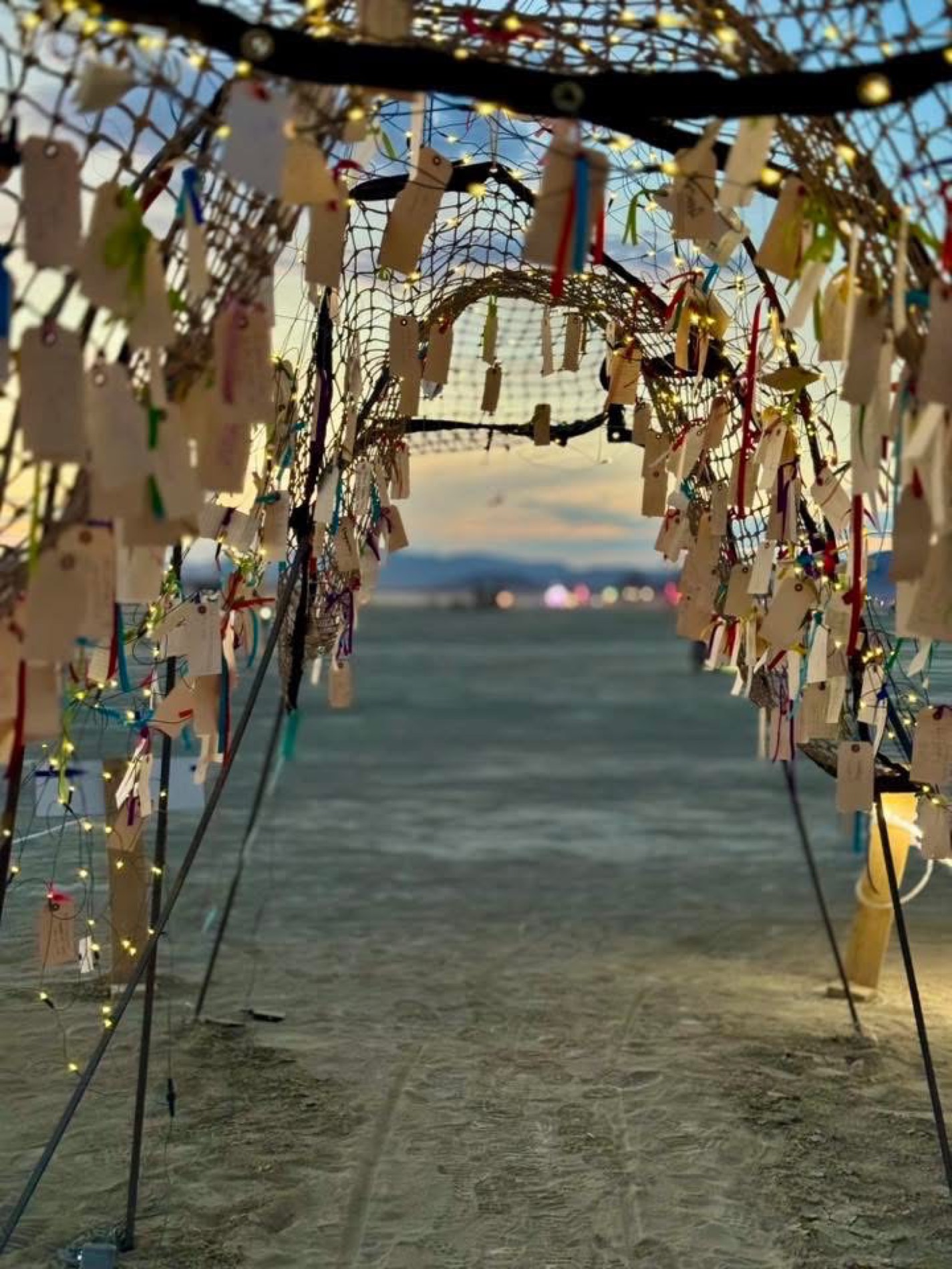 Seekers' riddles written on tags and woven into a lit net